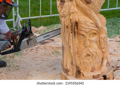 NIZHNY NOVGOROD, RUSSIA - JUNE 15, 2020: Summer Outdoor Festival. Man Carpenter, Wood Sculptor Using Chainsaw For Carving Wooden Sculpture. Carpentry, Craftsmanship, Design Concept