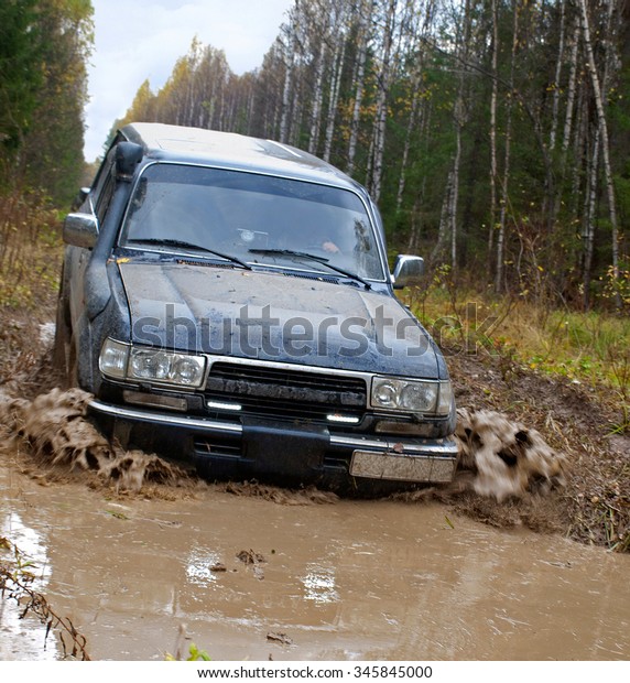 Nizhny\
Tagil, Russia - June 12, 2015: Russian Plain Road in the heart of\
Siberia. Wheel drive vehicle leaves the\
swamp