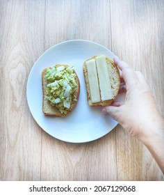 No Carbohydrate, Keto King Bread. Open Sandwich, Slices Of Bread Top With Cheese, Avocado, And Egg Paste Or Spread. Healthy Food Breakfast. Low Carb, High Fat, Good Fat. Picking Up Or Grabbing By Hand