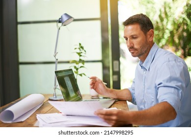 No Detail Is Too Small. Shot Of A Young Man Working From Home.