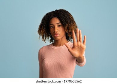 No Discrimination. Portrait Of Serious Young Black Woman Showing Stop Gesture At Camera, Millenial African American Female Standing With Outstretched Hand, Isolated Over Blue Background, Copy Space