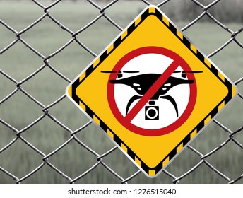 No drone zone Warning sign at fence wall, Prohibition sign to fly with drones on the net fence. No drone zone, No drone flying at perimeter fence netting of airport airspace or Detention Center
