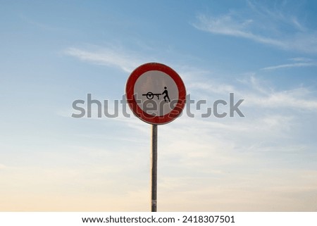 No entry for handcarts traffic sign, isolated sunset sky.