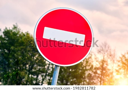 No Entry road sign agains the sky. The road is closed red round sign. White brick in red circle road sign. 