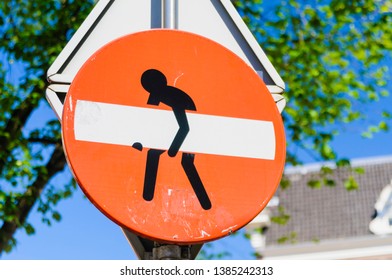 No Entry street sign which has been doctored to make it look like a person is picking up a large white object
