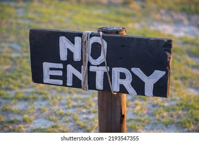 No Entry Wooden Rustic Sign On A Lawn  At Sunset