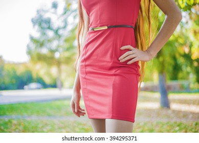 No Face. Girl Or Woman In Red Luxury Dress And Black Elegant Belt Posing On Street In Summer Park