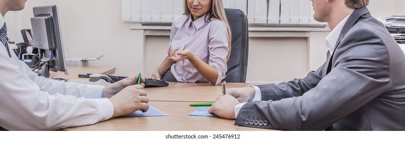 No Face Unrecognizable Person Three Business People Sitting At Table With Papers And Pc Computer And Planning Against Texture Window In Wall Background Woman Sit In Leather Armchair Near Keyboard