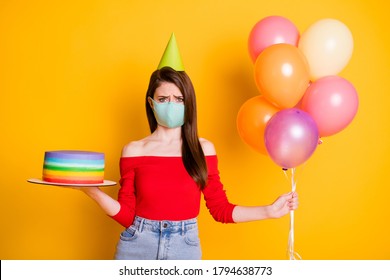 No Guest Anniversary Party. Upset Girl In Medical Mask Celebrate Birthday Hold Balloons Cake Frustrated Wear Red Casual Top Denim Jeans Cone Isolated Over Bright Shine Color Background