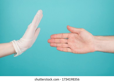 No handshakes at time of Coronavirus quarantine concept. Cropped close-up photo of woman not accepting a handshake offer as a greeting isolated on turquoise background