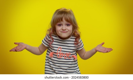 No Idea, I Dont Know Answer. Puzzled Clueless Uncertain Blonde Kid Child Raising Hands In Helpless Gesture, Embarrassed Confused By Difficult Question. Teenager Children Girl On Yellow Wall Background