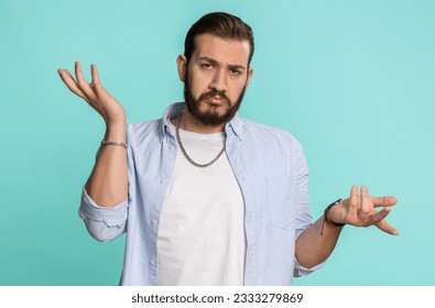 No idea, I dont know answer. Puzzled clueless uncertain lebanese handsome man raising hands in helpless gesture, embarrassed confused by difficult question. Confused one guy on blue studio background