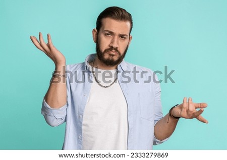 No idea, I dont know answer. Puzzled clueless uncertain lebanese handsome man raising hands in helpless gesture, embarrassed confused by difficult question. Confused one guy on blue studio background