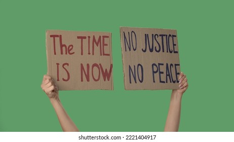 NO JUSTICE NO PEACE and THE TIME IS NOW. Protests text messages on sign cardboard. Stop racism. Police violence. Banner design concept. Hands of women raising up poster on green screen. - Powered by Shutterstock