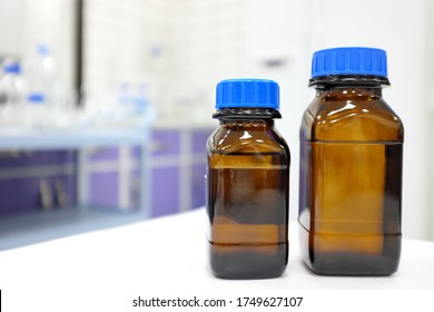 No Label Amber Glass Bottle With Clear Liquid Chemical Inside A Laboratory With Copy Space.