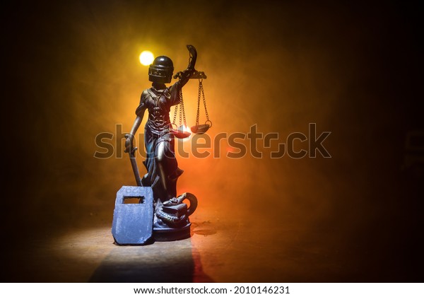 No law\
or dictatorship concept. The Statue of Justice with anti-riot\
police helmet holding scale. Creative artwork decoration with\
colorful toned foggy background. Selective\
focus
