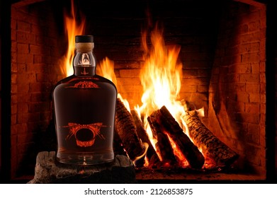 NO LOGO. NO TRADEMARK. View of a bottle of rum, whiskey on the background of a fireplace fire. High quality photo