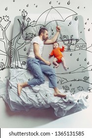 No matter what the weather. Top view photo of young man and his child sleeping in a big white bed. Dreams concept. Painted dream about rain, weatherness, walk, umbrella, autumn, father's protection.
