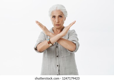 No Means Not. Portrait Of Serious-looking Strict And Wise Elderly Mother With White Hair Making Cross With Arms Raised Near Chest Looking At Camera Prohibiting Or Forbidding Playing Risky Games