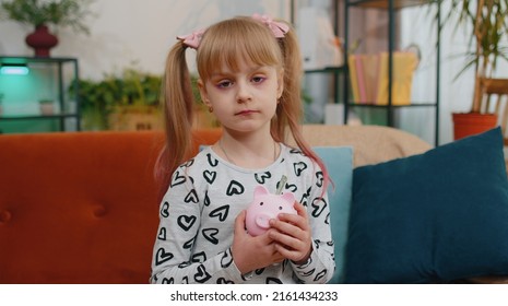No Money. Frustrated poor little toddler kid girl hold almost empty piggybank with only one dollar cash. Children at home alone. No savings, wrong budget planning, low interest on deposit, bankruptcy