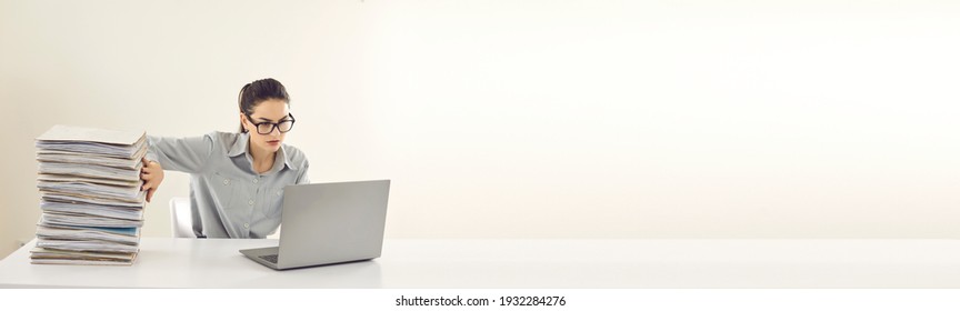 No more piles of papers, store them in digital computer database instead. Office manager or accountant sitting at desk, doing paperwork, entering data in electronic system on laptop. Copy space banner