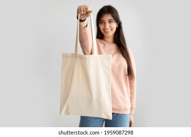 No More Plastic. Cheerful Millennial Woman Showing White Eco Bag To Camera Standing Over White Studio Background. Lady Holding Flax Shopper Handbag. Fashion And Ecology Concept, Selective Focus