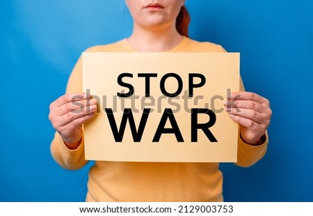 No more war. Woman hands holding banner with inscription stop war, protesting on a blue background