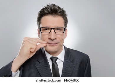 No More Word. Portrait Of Confident Businessman Holding His Finger On The Lips And Looking At Camera