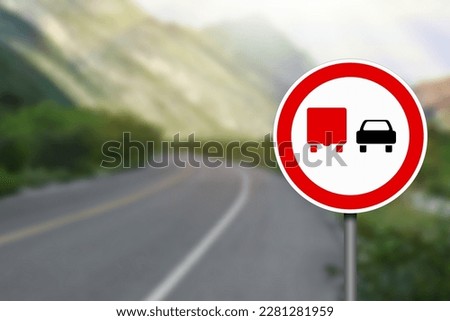 No Overtaking By Heavy Goods Vehicles road sign on highway, space for text