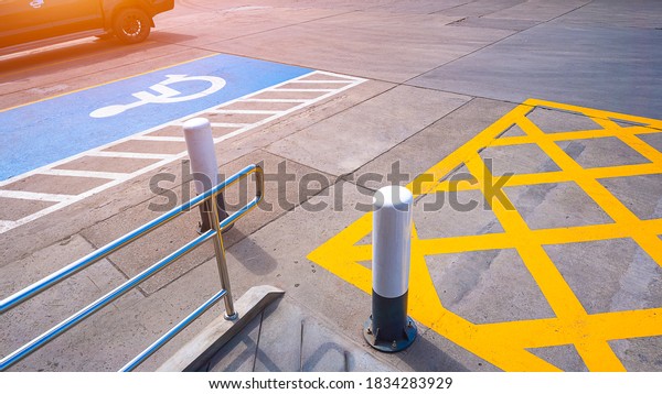 No parking with disabled wheelchair sign and\
railing on concrete ground surface in parking lot of public\
restroom area at petrol\
station