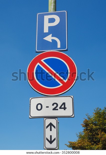 No parking here, cars parking on the left traffic
sign over the blue sky
