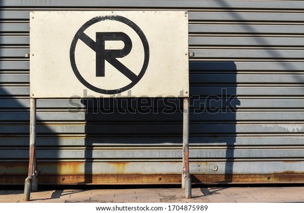 No Parking sign board with metal door background\
in Bangkok Thailand