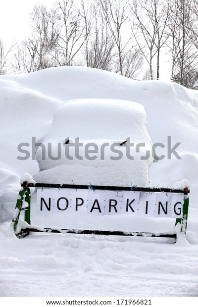No Parking sign\
with car covered in snow