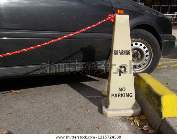 No parking sign and car\
next to it.