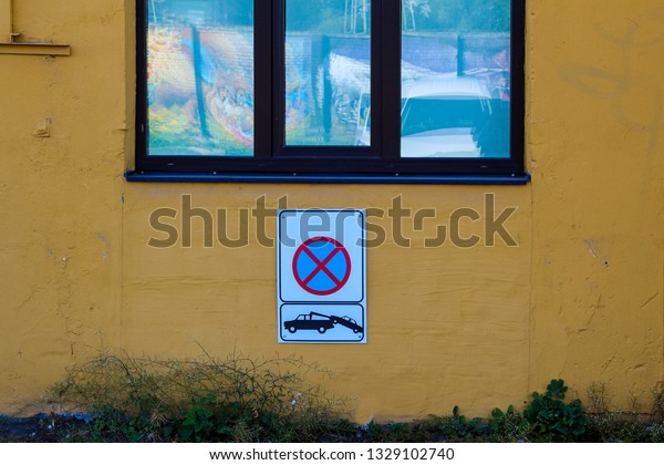 No\
parking sign hanging on the wall.\
Car evacuation\
sign
