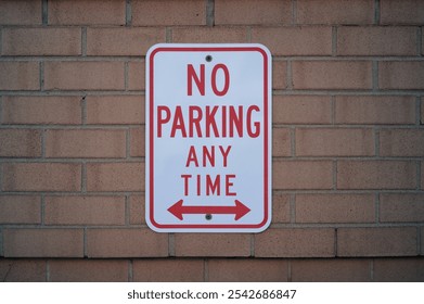 No parking sign on the red brick wall clearly marking restricted area with copy space. - Powered by Shutterstock