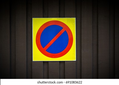 No parking sign. Prohibition symbol. Sign indicating warning and forbidden. Grunge shabby paper sticker isolated on dark wooden background.