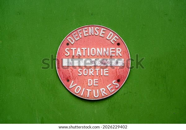 No parking\
sign written in French. Parking forbidden, Car exit. Red circle\
over green background, vintage\
style.