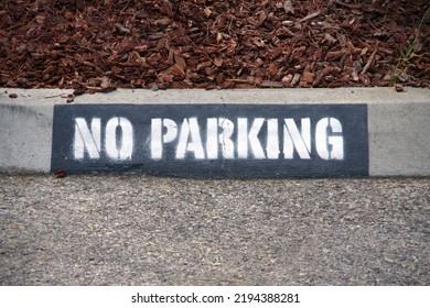 NO PARKING Signage On A Curb Stone