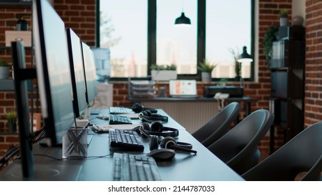 No People At Desk With Multiple Computers In Call Center Office, Used By Telemarketing Agents To Answer Phone Calls On Helpline. Empty Space With Technology To Give Assistance At Customer Care.