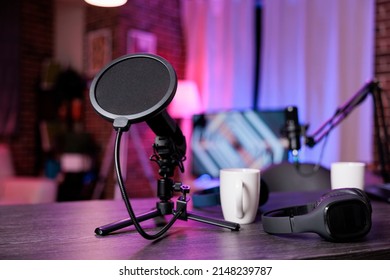 No people at empty desk with recording equipment to broadcast live conversation on social media. Nobody in space with podcast station, microphone and headphones, sound production.