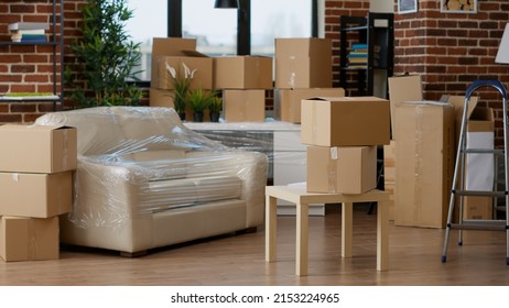 No people in empty living room apartment with carton boxes on stack, moving cardboard storage packaging in new household. Nobody in relocation property with interior furniture cargo. - Shutterstock ID 2153224965