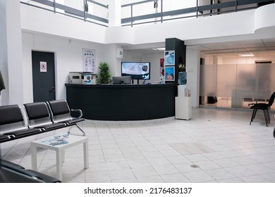 No people in waiting area for patients with doctor appointments in modern healthcare clinic in private practice hopital. Empty waiting room with front desk reception with promotional flyers.