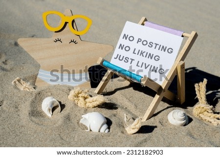 NO POSTING NO LIKING JUST LIVING text on paper greeting card on background of beach chair lounge starfish summer vacation decor. Concept of social media technology detox Sandy beach sun. Holiday