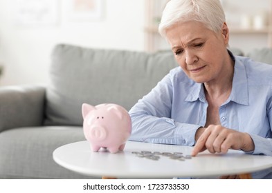 No Retirement Savings. Upset Elderly Woman Counting Last Coins From Piggy Bank, Sitting Depressed At Home