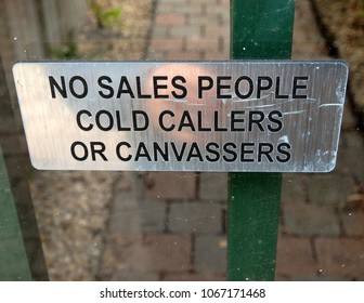 No sales people, cold callers or canvasser silver sign on glass door