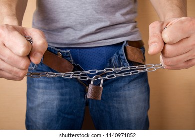 No Sex. Prohibition Of Abstinence Of Sexual Relations. Man Holds Chain With Lock In The Groin Area