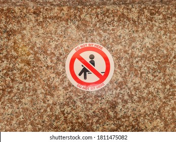 No sit sign sign stuck on marble surface