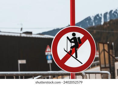 A no ski climbing sign prominently displayed against a backdrop of distant mountains and a metal barrier. Amidst nature’s beauty lies danger heed the warning signs to ensure a safe experience. - Powered by Shutterstock