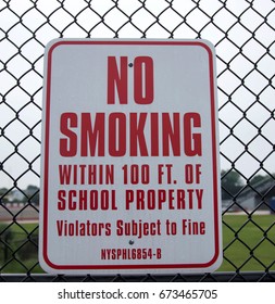 A No Smoking Sign Hangs On A Fence At A Local High School